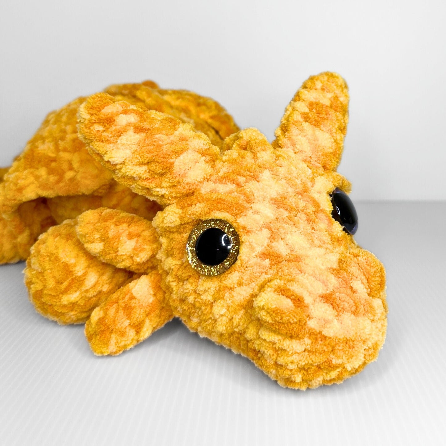 Handmade Golden Feathertail Dragon Crochet Plush — Large Laying Fantasy Dragon in Warm Gold Velvet Yarn - pursuitofcraftyness